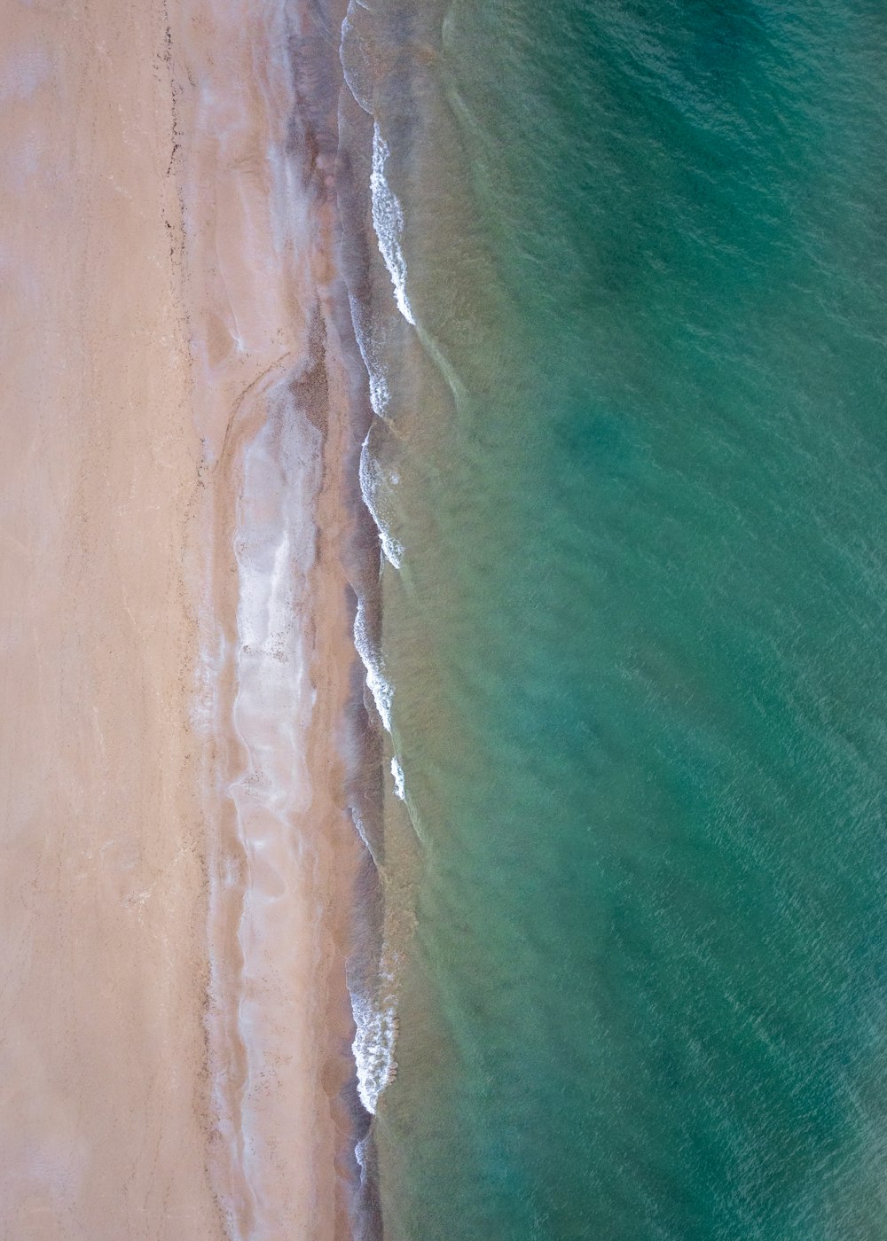 an aerial view of a sandy beach and ocean