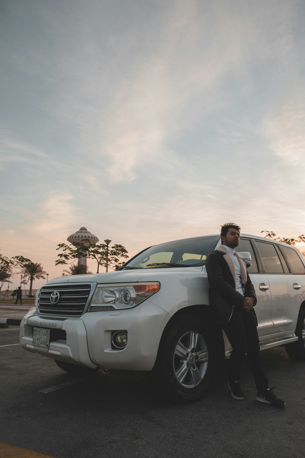 a man standing next to a white suv