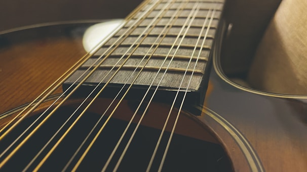Close-up of a vintage acoustic guitar being carefully repaired on a workbench.