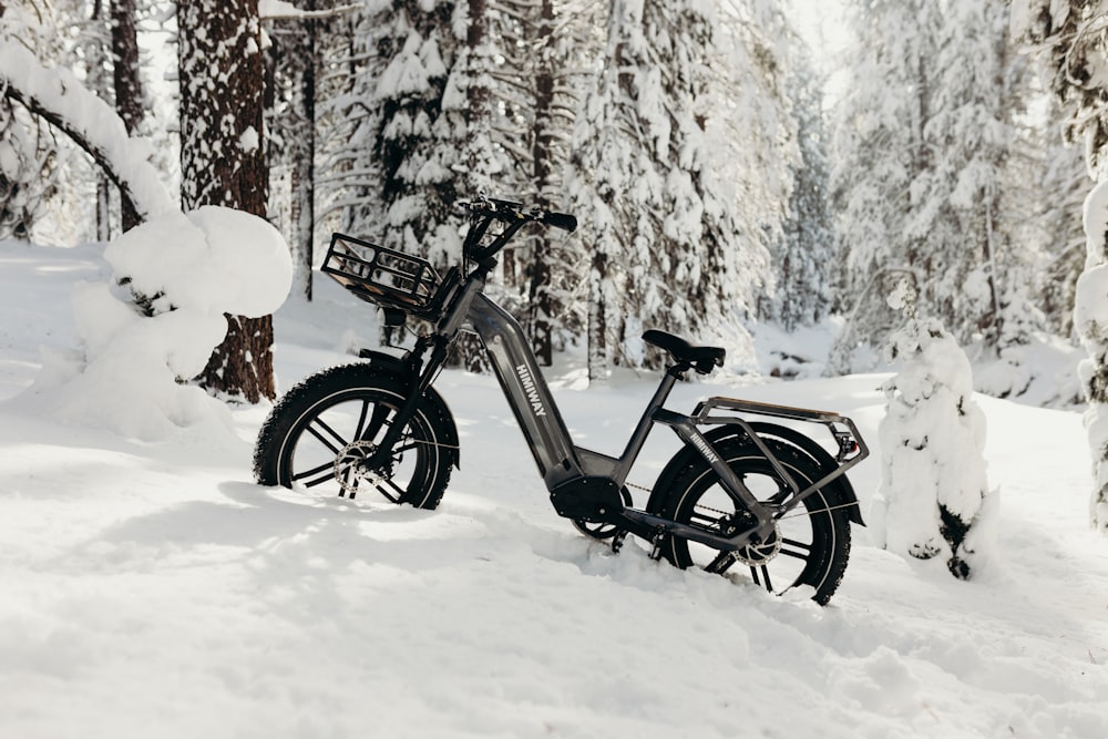 a bicycle parked in the snow in the woods