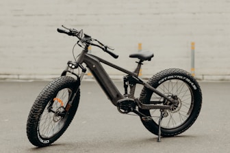 Modern electric bike leaning against a wall with its battery detached