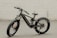 A black, modern fat-tire electric bike is positioned against a smooth, pale background. The bike features thick, rugged tires suitable for off-road terrain and a sleek carbon fiber frame. The battery and motor are integrated into the frame, highlighting its electric capability.