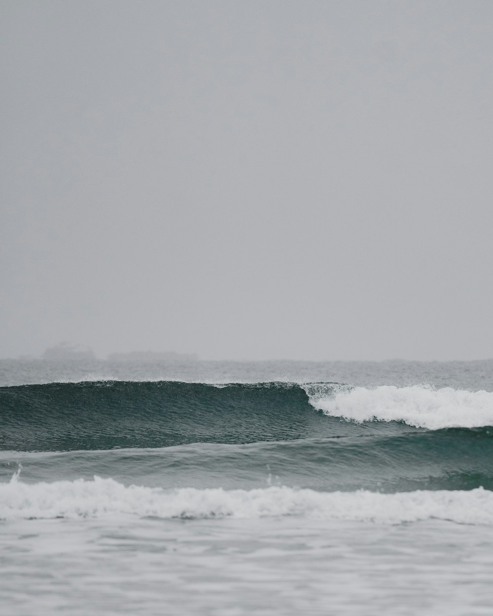 a man riding a wave on top of a surfboard