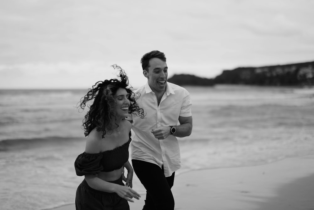 a man and a woman walking on the beach