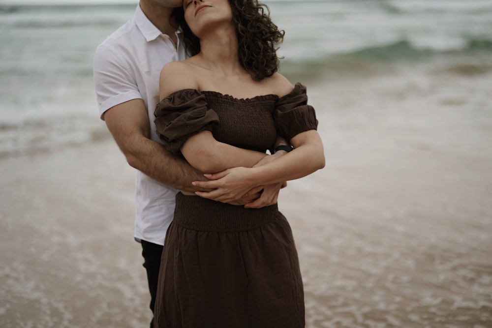 a man and a woman standing next to each other on a beach