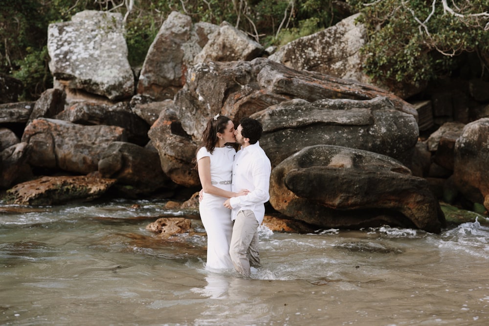 a man and a woman are standing in the water