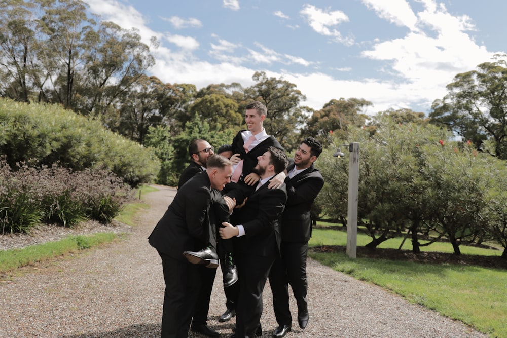 a group of men in tuxedos posing for a picture