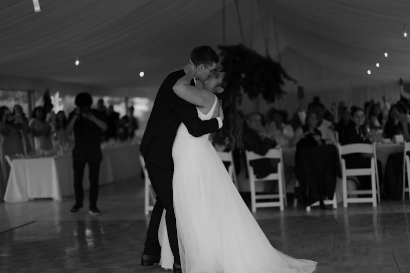A couple's first dance in a candlelit reception tent