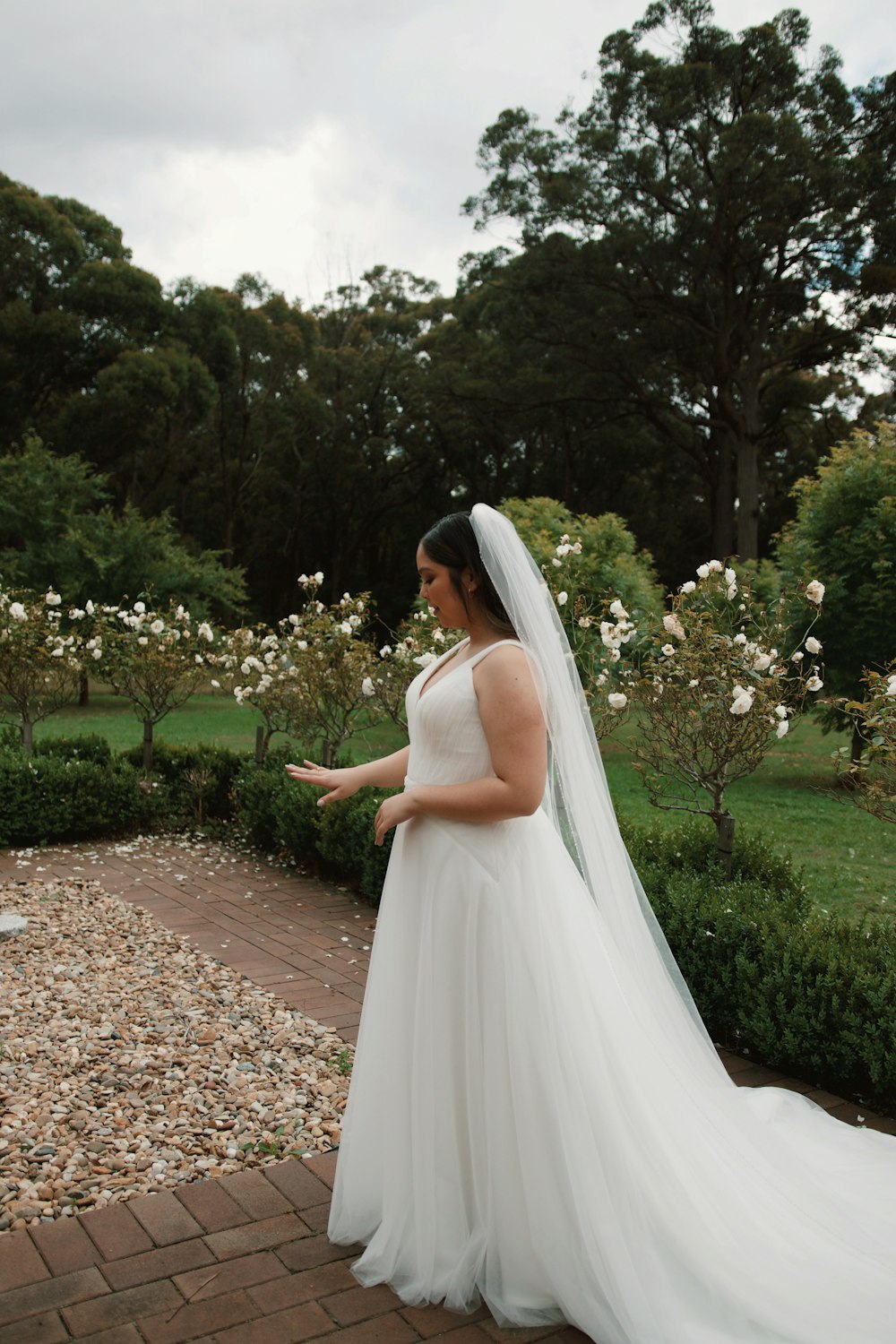 a woman in a wedding dress standing in a garden