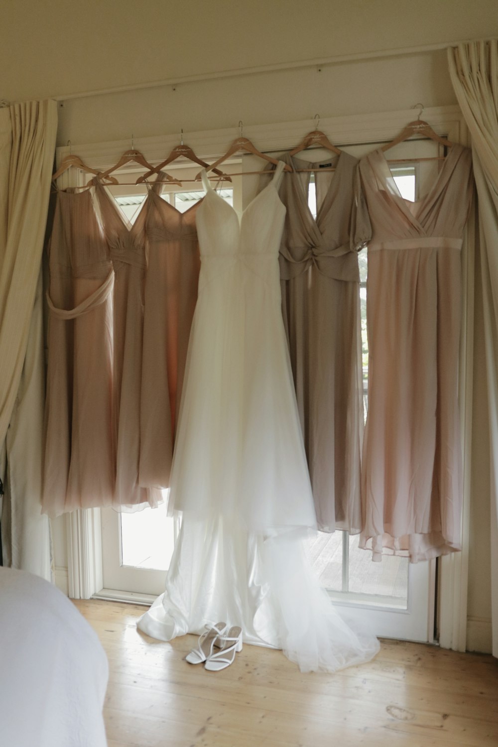 a bride's dress hanging in front of a window