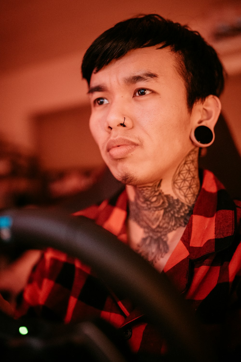 a man with tattoos on his neck driving a car