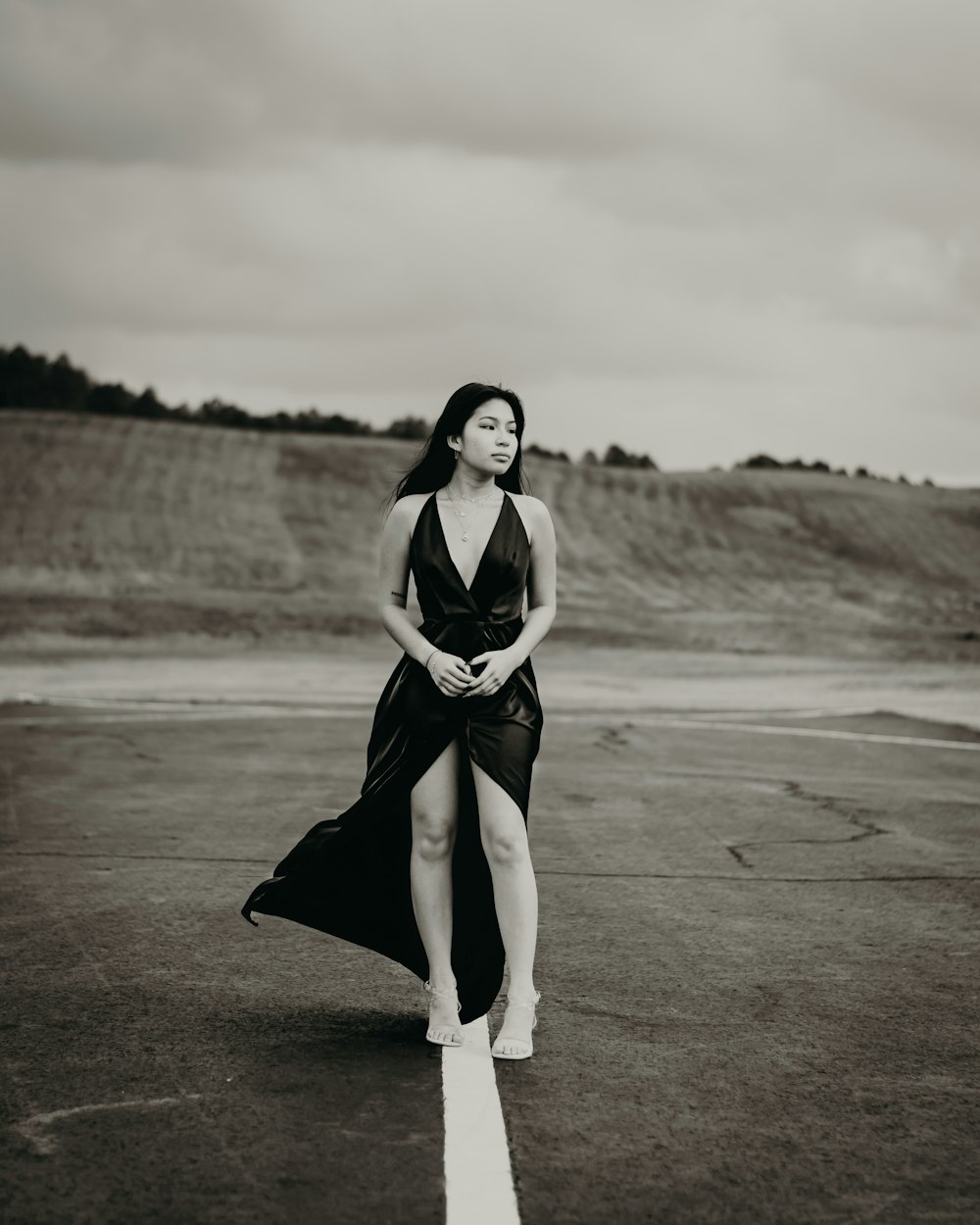 a woman in a black dress standing on a runway