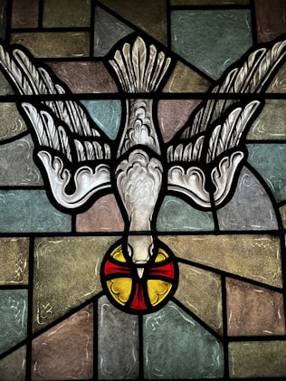 a stained glass window with a bird on it