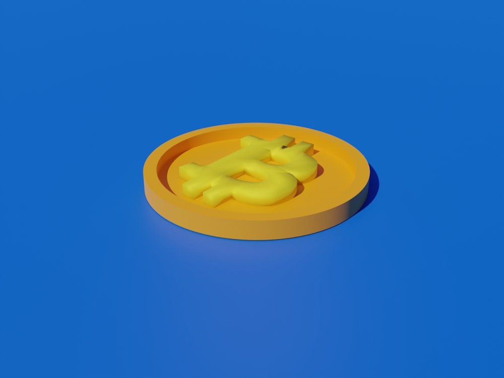 ein gelber Kunststoffgegenstand, der auf einer blauen Oberfläche sitzt