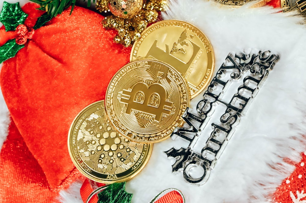 a pile of gold bitcoins sitting on top of a pile of christmas decorations