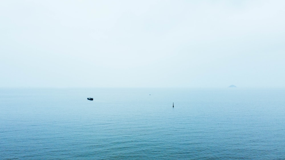 a couple of boats floating on top of a large body of water