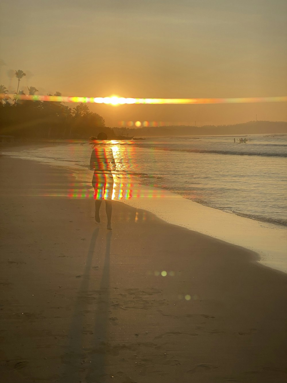 a person standing on a beach at sunset