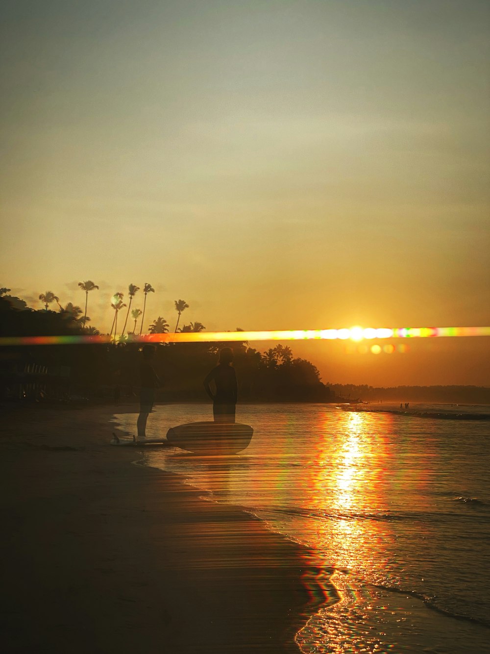 a couple of people standing on top of a beach