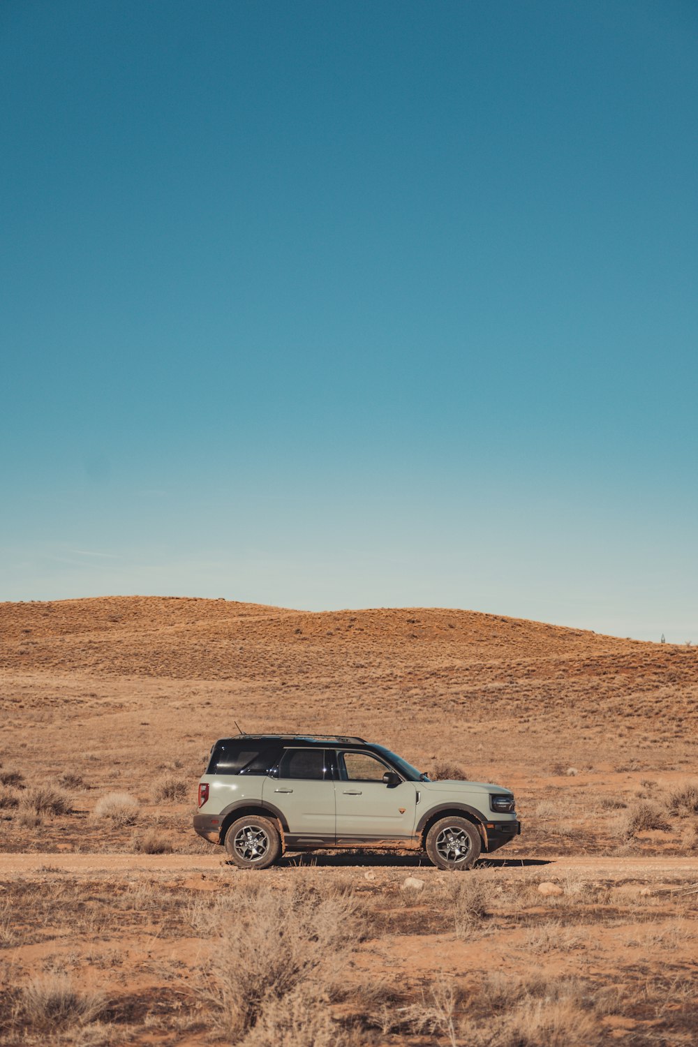 a car is parked in the middle of the desert