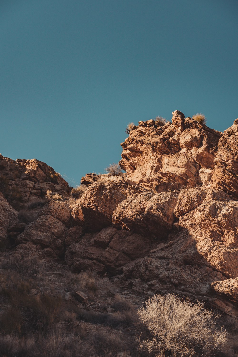 a lone bird is perched on a rock formation