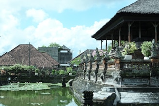 a pond in front of a building with a clock tower in the background
