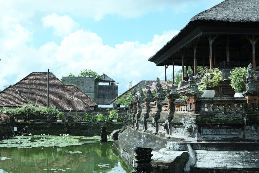 a pond in front of a building with a clock tower in the background