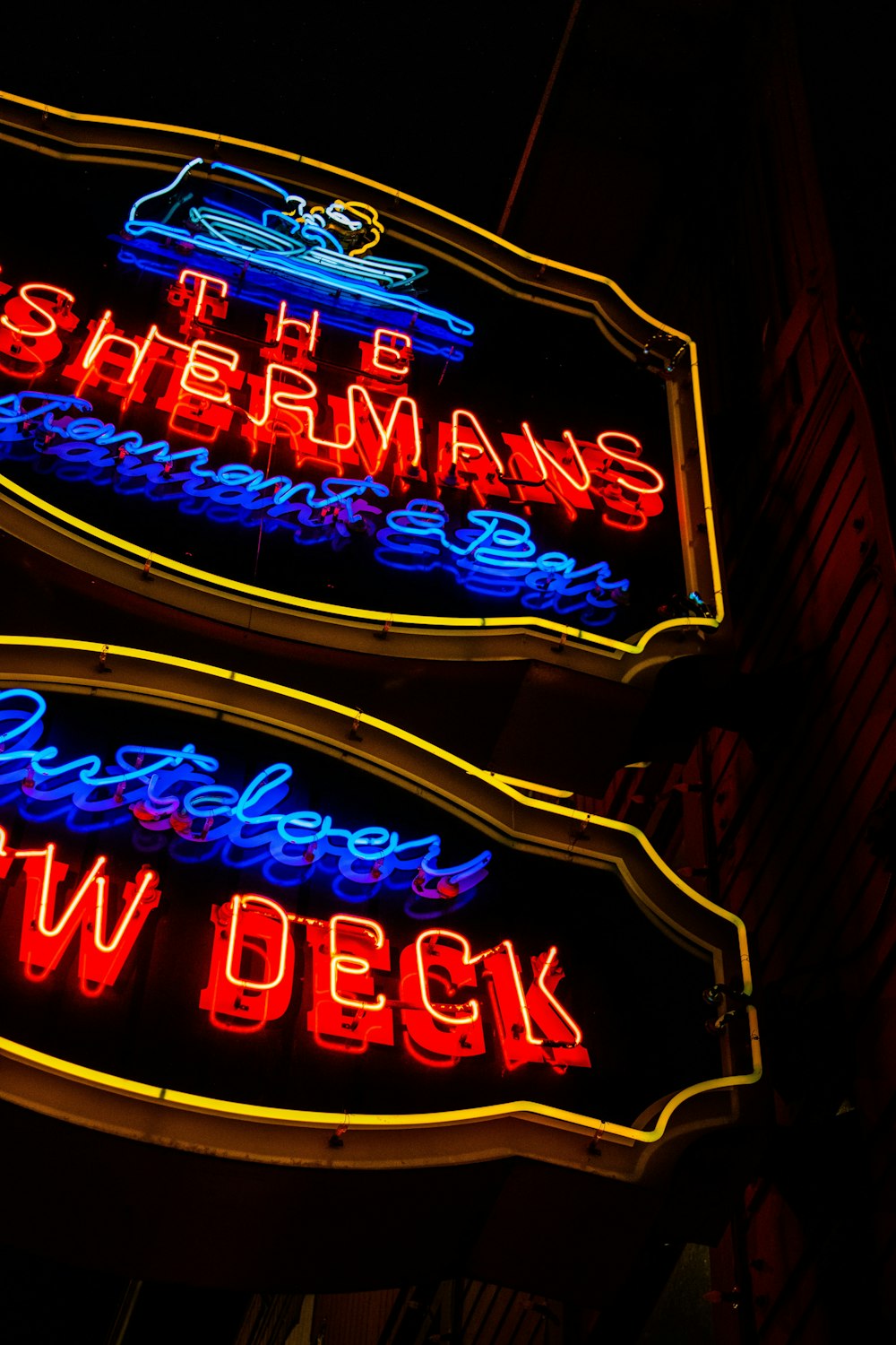 a couple of neon signs that are on the side of a building