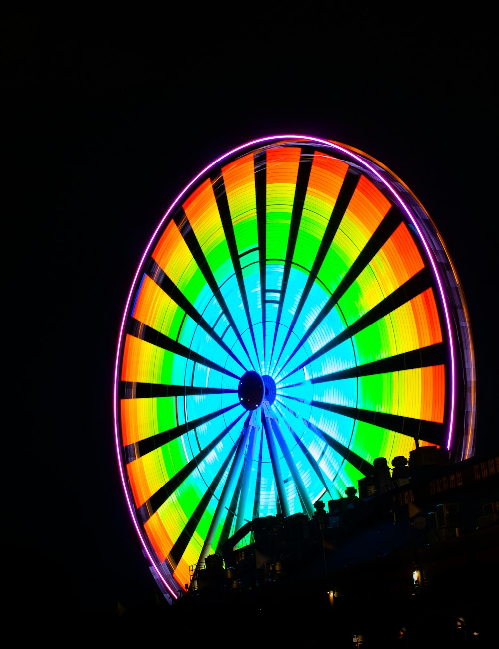 a colorful ferris wheel lit up at night