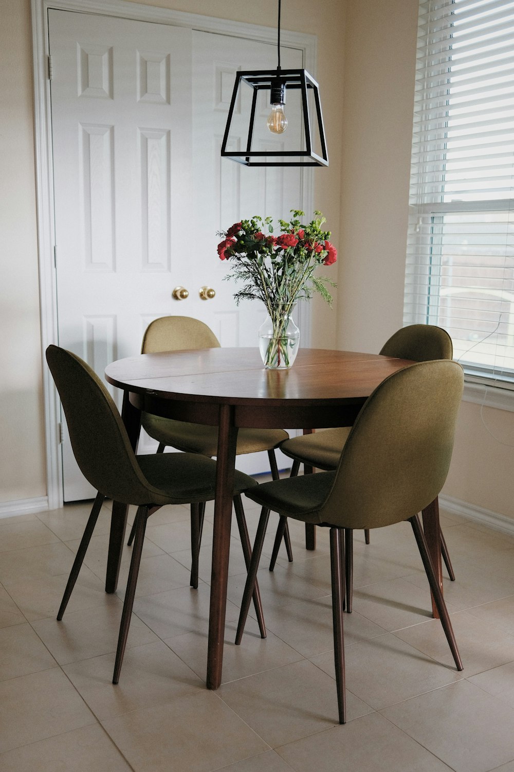 a dining room table with a vase of flowers on it