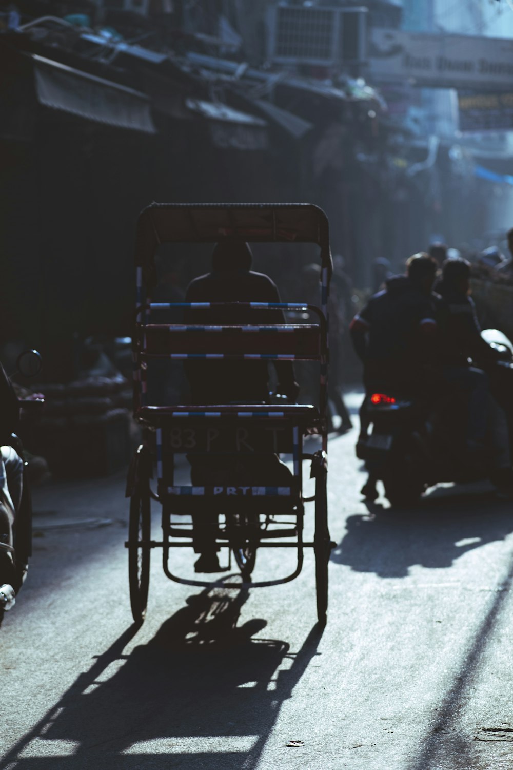 a man riding a motorcycle with a cart on the back of it