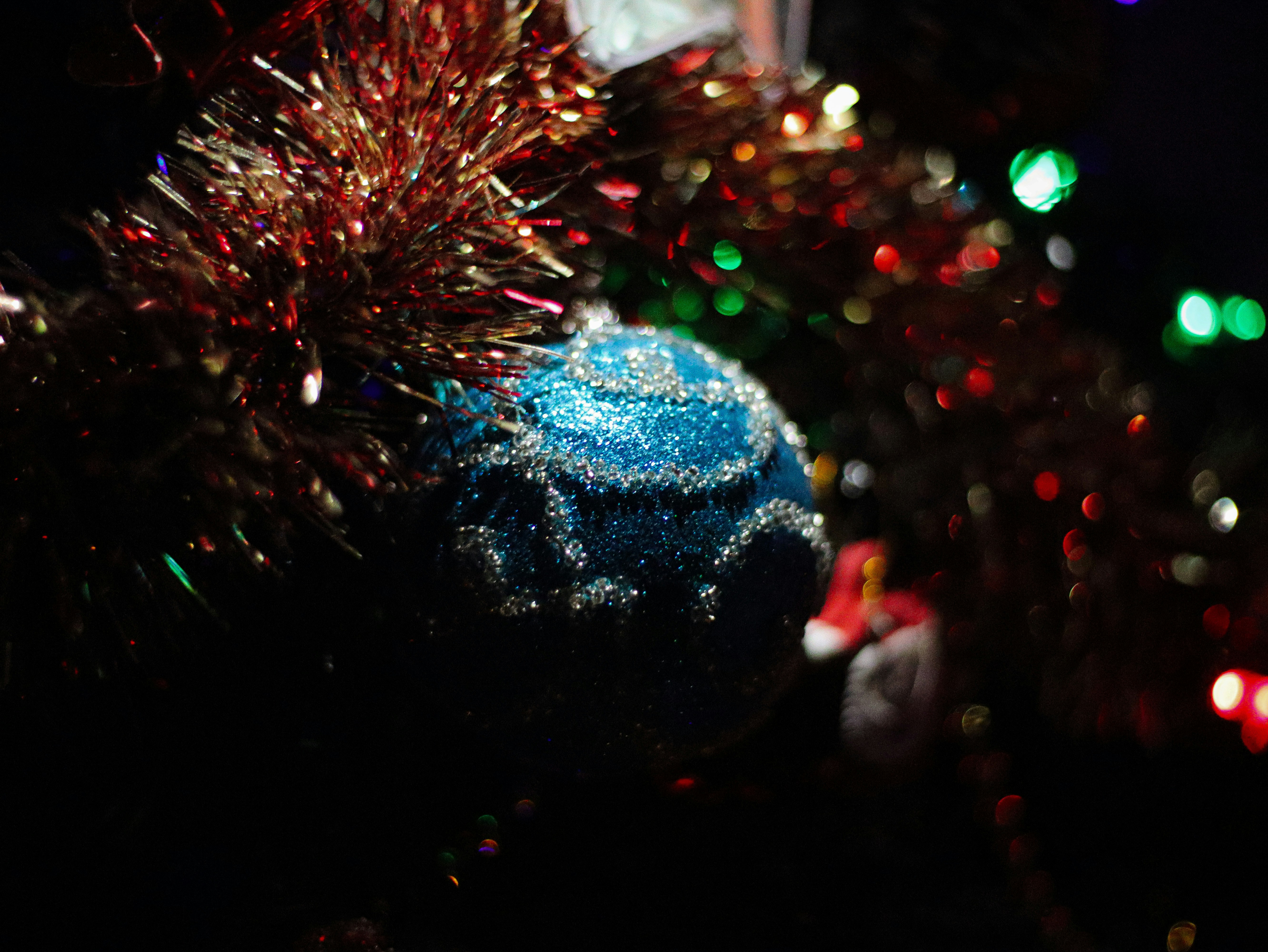 Close de um enfeite azul de Natal em uma árvore.