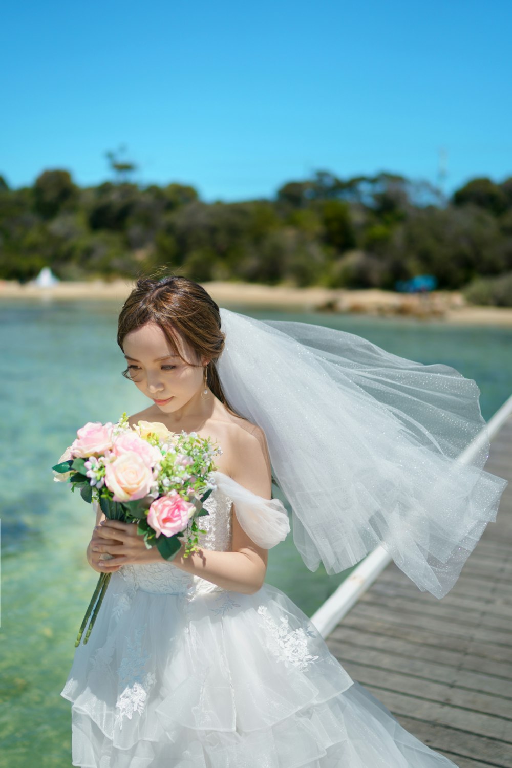 a woman in a wedding dress holding a bouquet of flowers