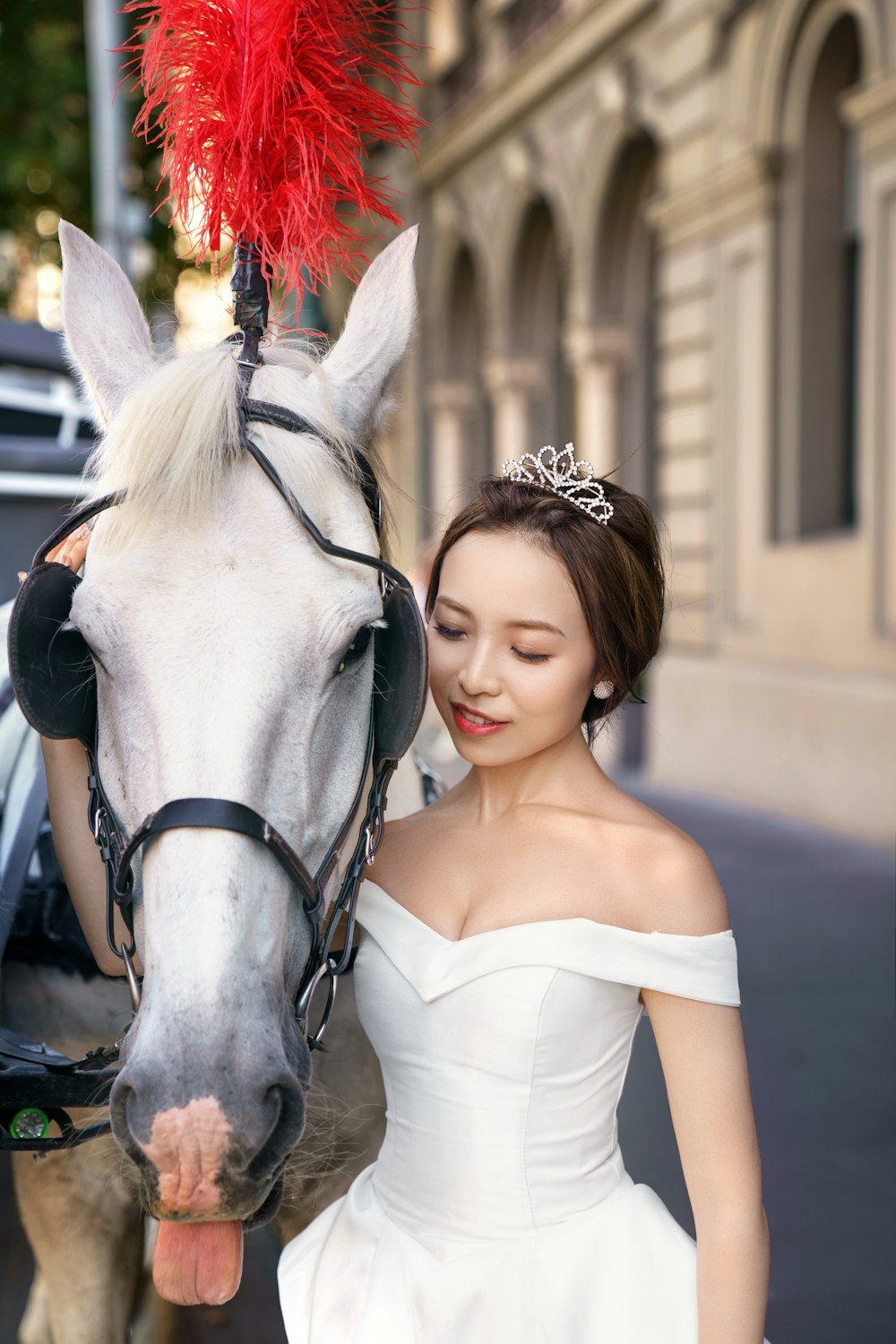 a woman in a white dress standing next to a horse