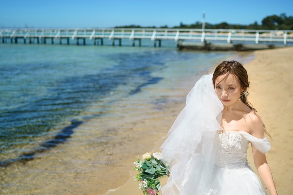 a woman in a wedding dress on the beach