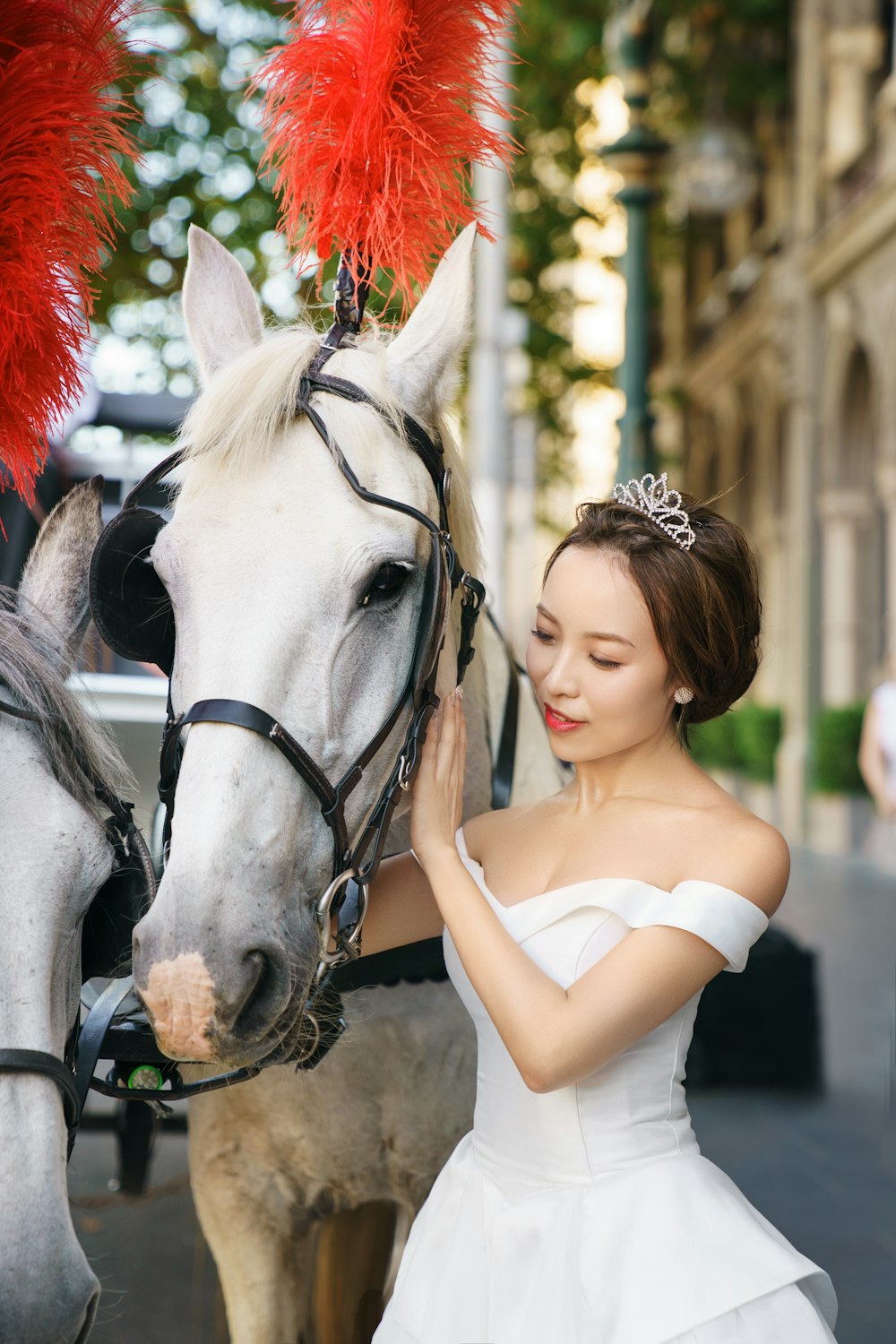 a woman in a white dress petting a horse