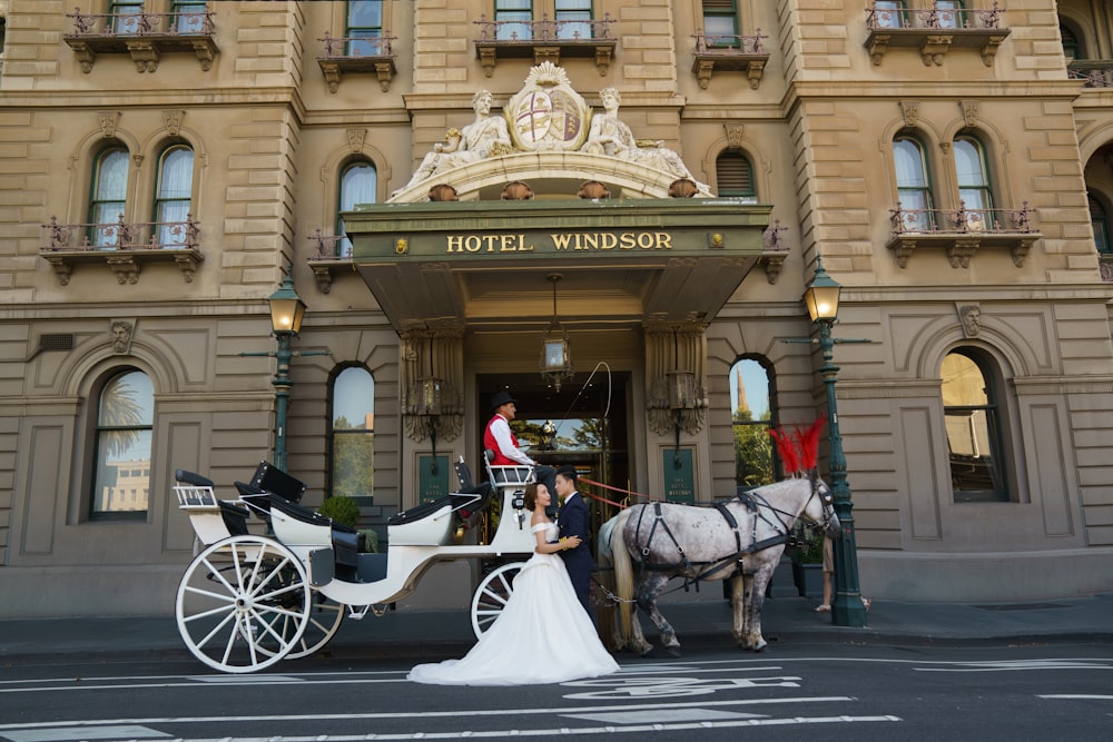 a bride and groom standing in front of a hotel