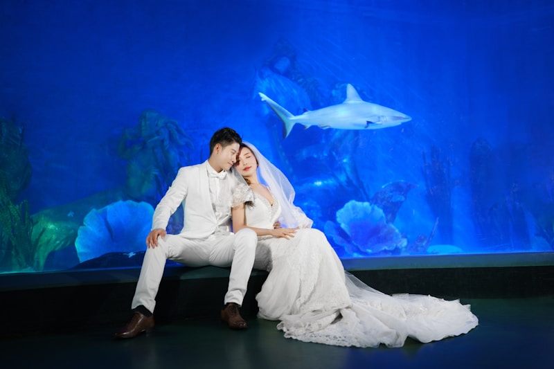 a bride and groom sitting in front of an aquarium