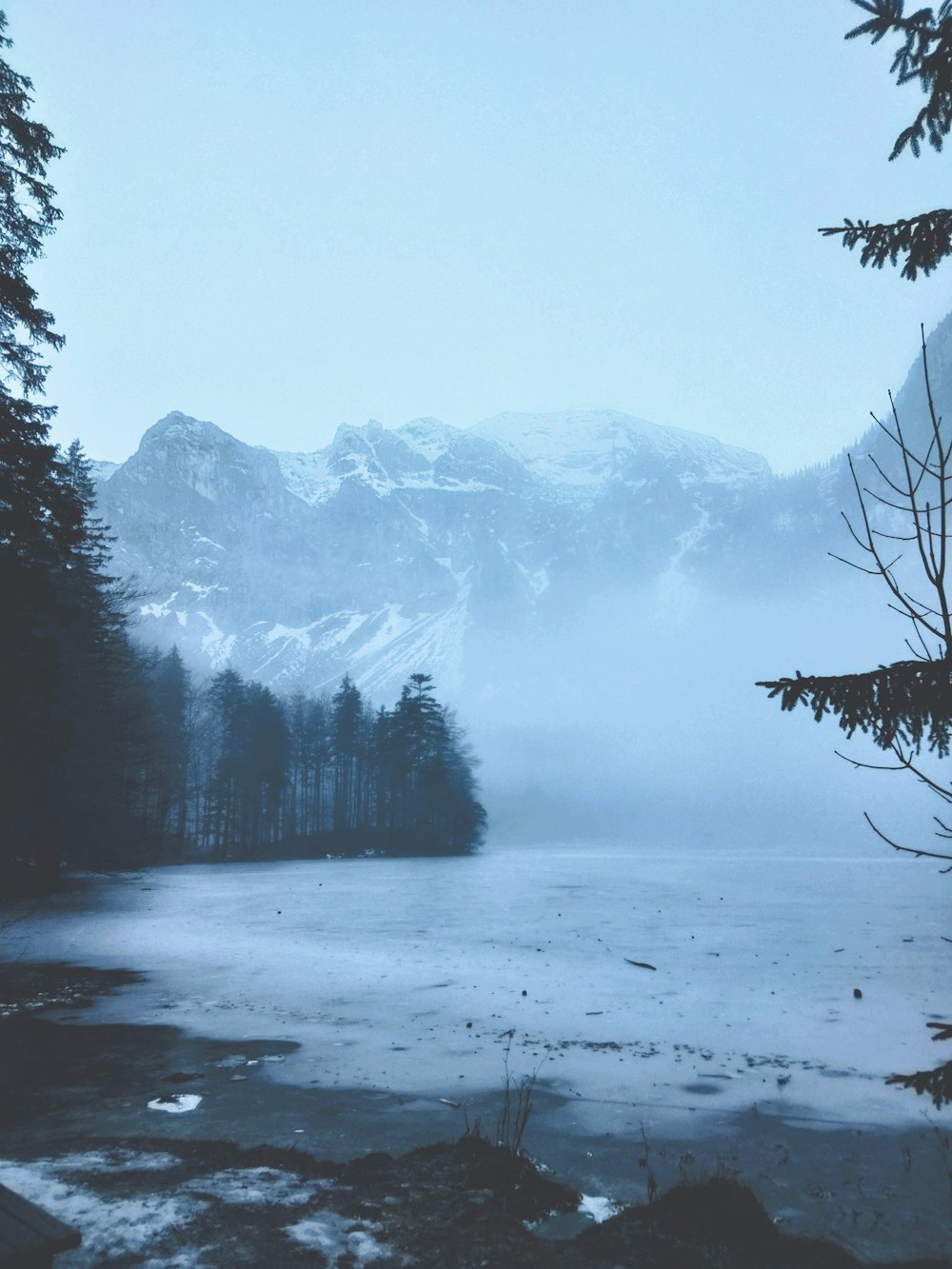 a body of water surrounded by snow covered mountains