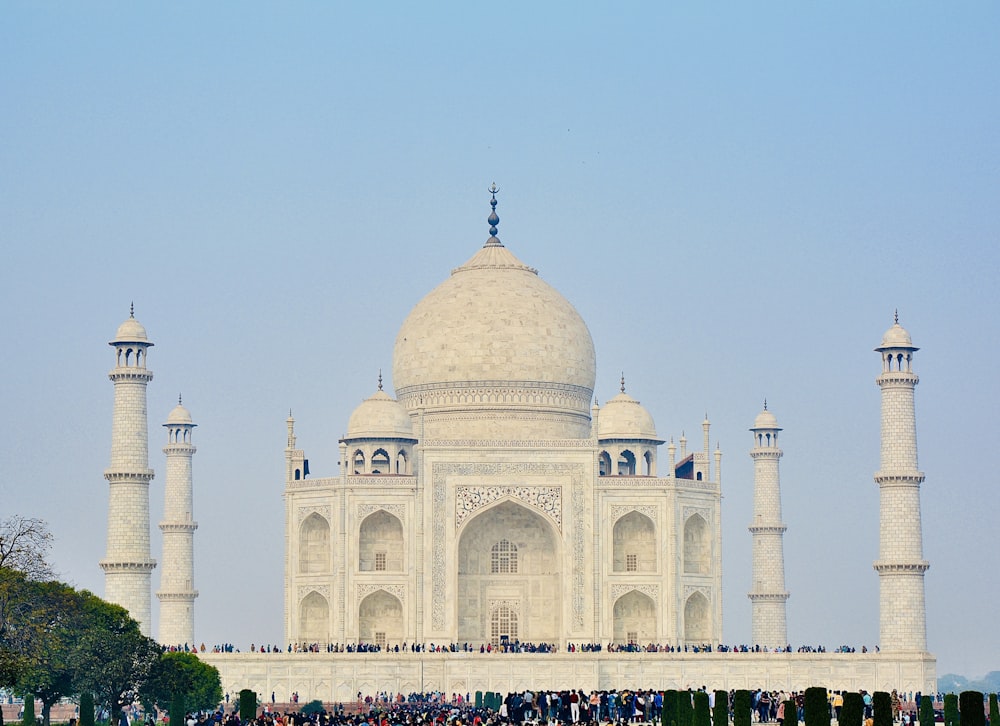 a group of people standing in front of a white building