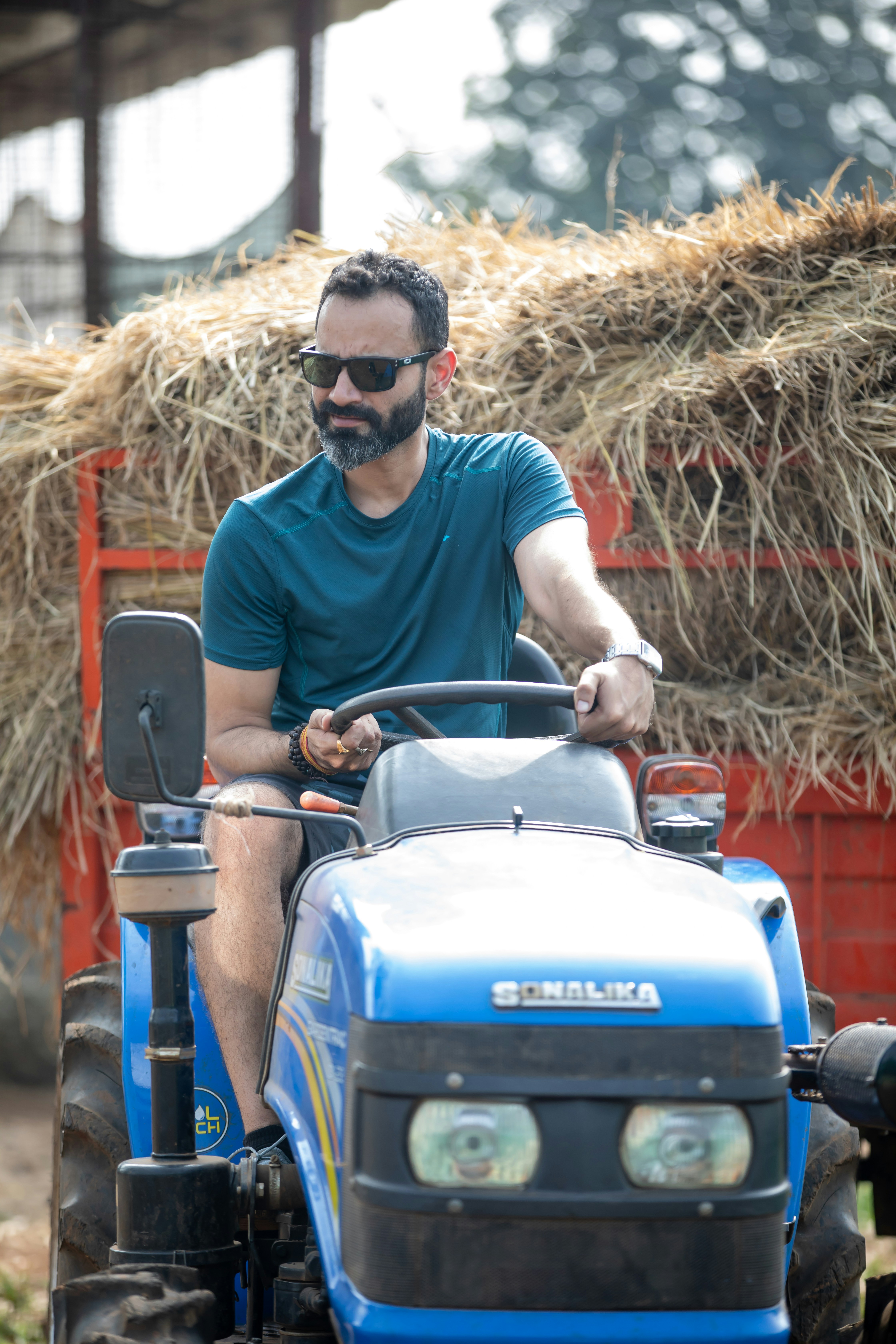 A man riding on the back of a blue tractor photo – Free Grey Image on ...