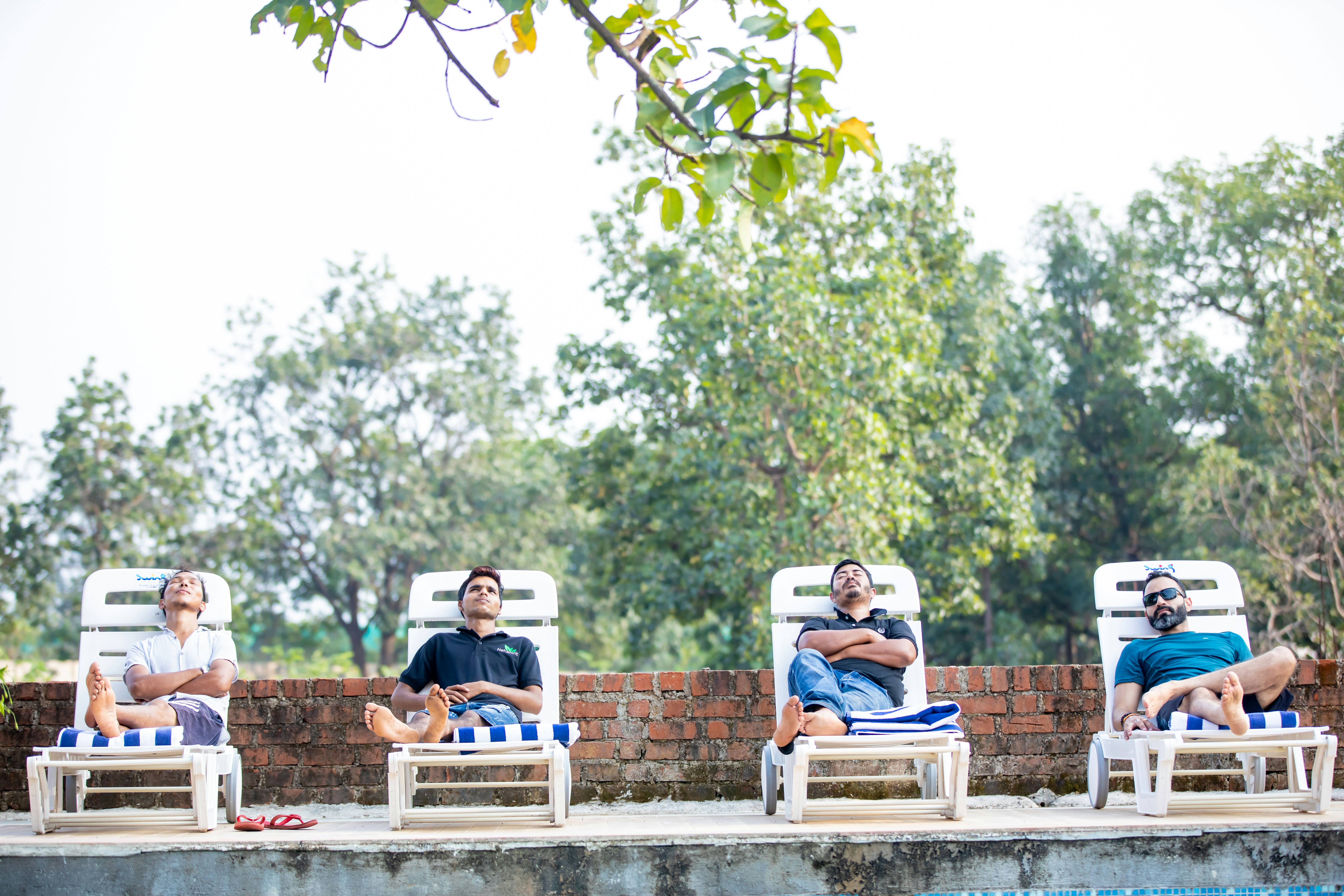 People relaxing on lounge chairs by a rooftop pool - apartment rooftop patio with pool