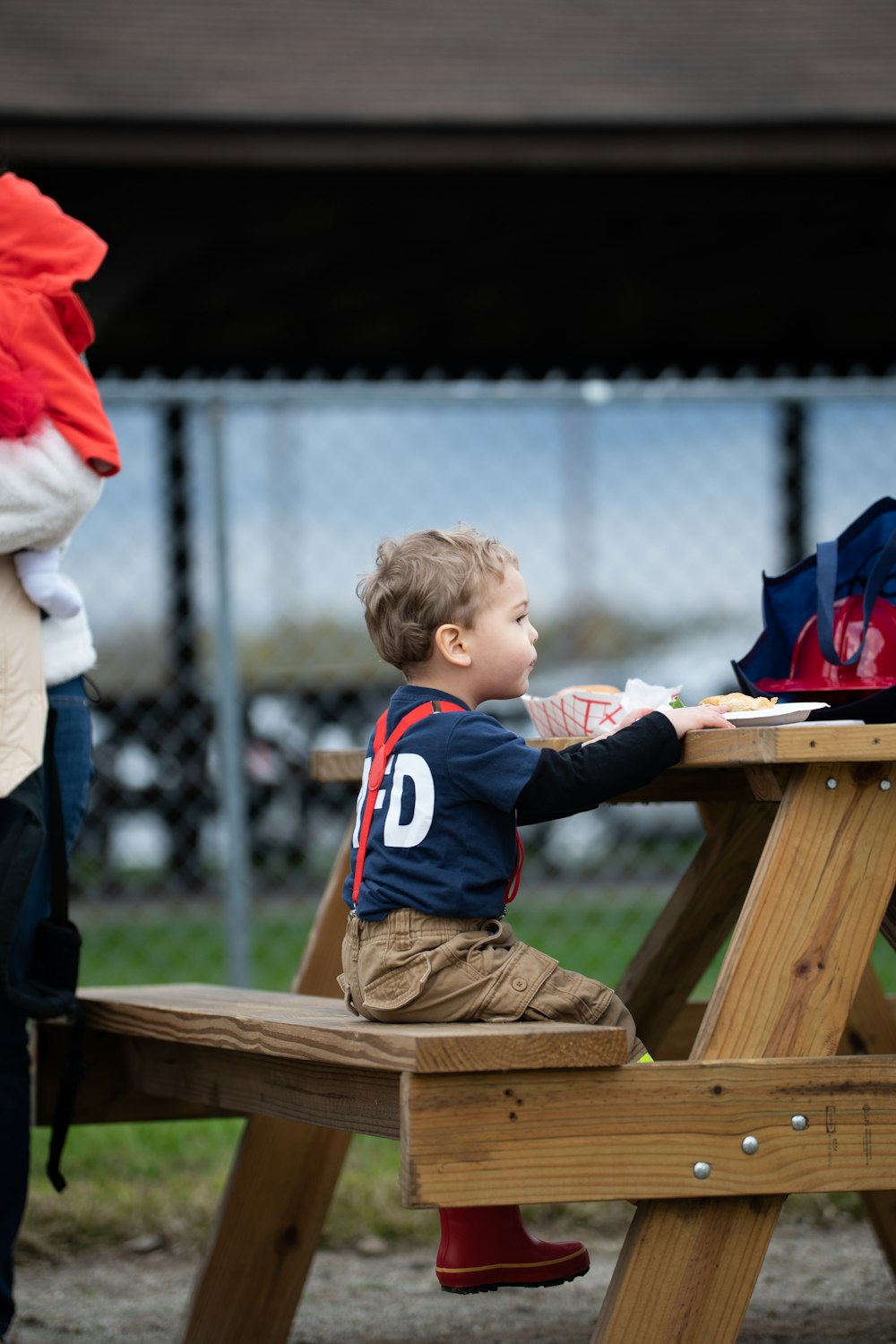 a little boy sitting at a picnic table