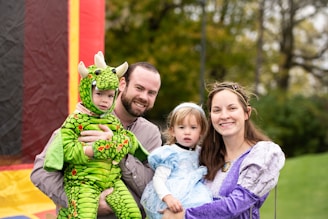 a man, woman and child pose for a picture in front of a boun