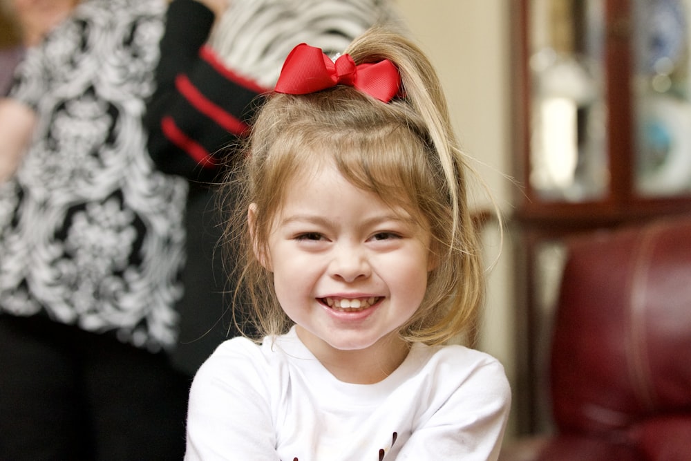 a little girl with a red bow in her hair