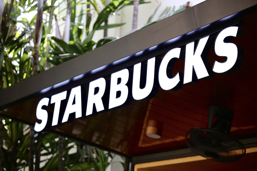 a starbucks sign hanging from the side of a building