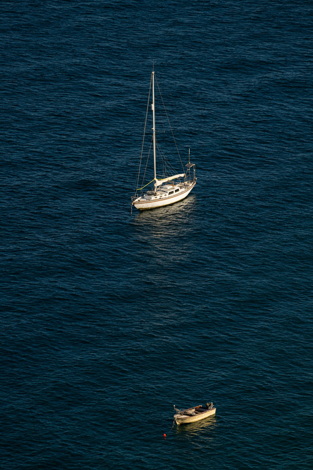 a sailboat and a small boat in the ocean