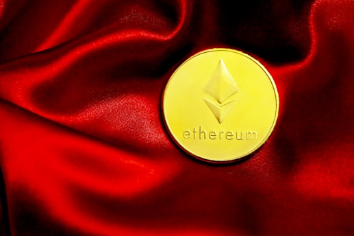 a close up of a red cloth with a gold coin