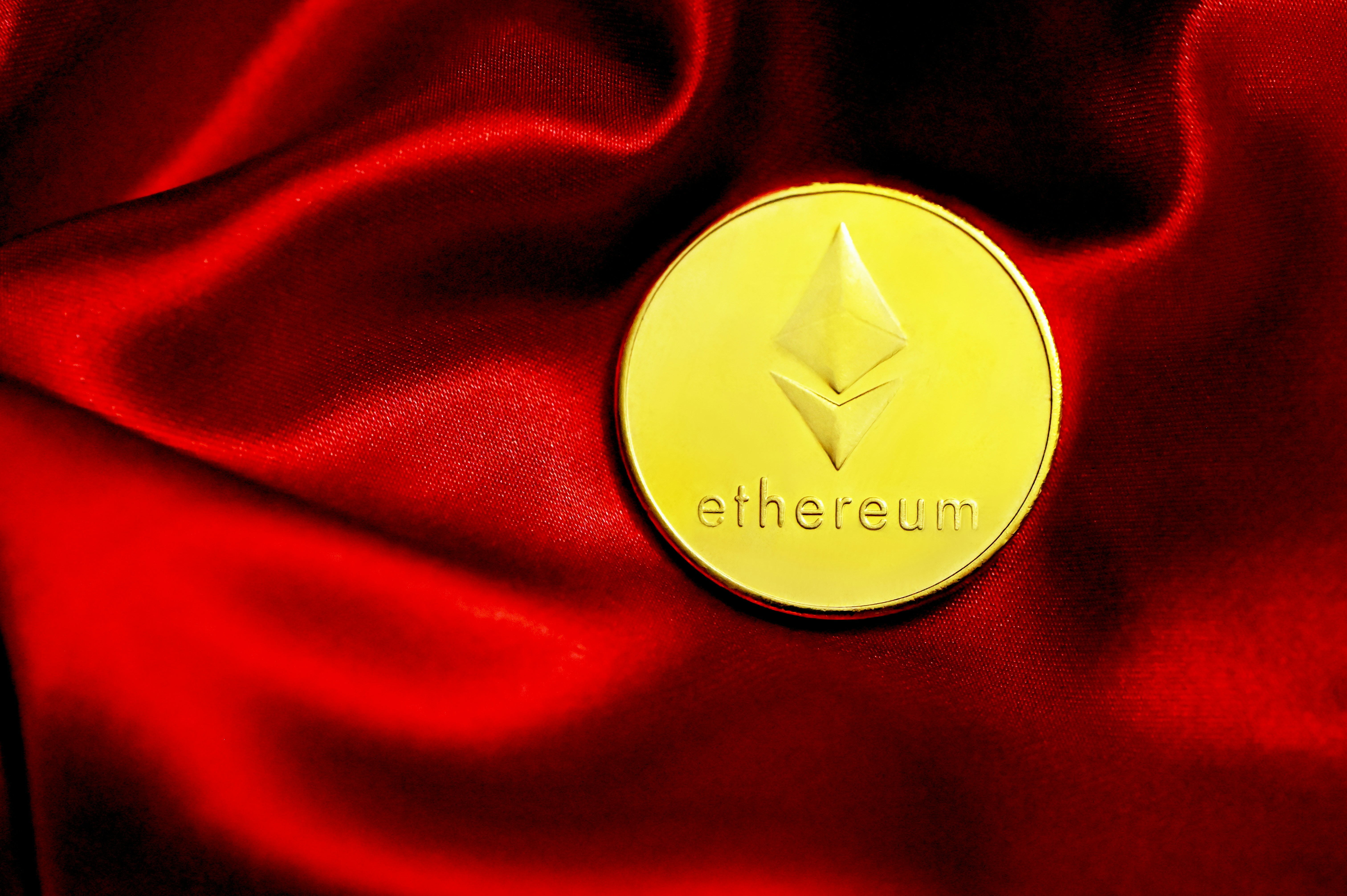 A single Ethereum coin placed on red velvet