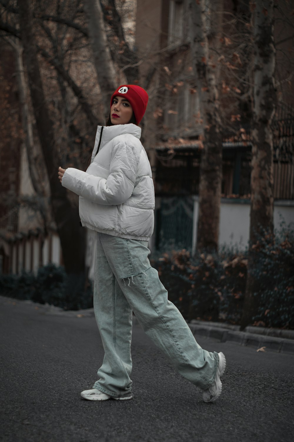 a person walking down a street with a red hat on