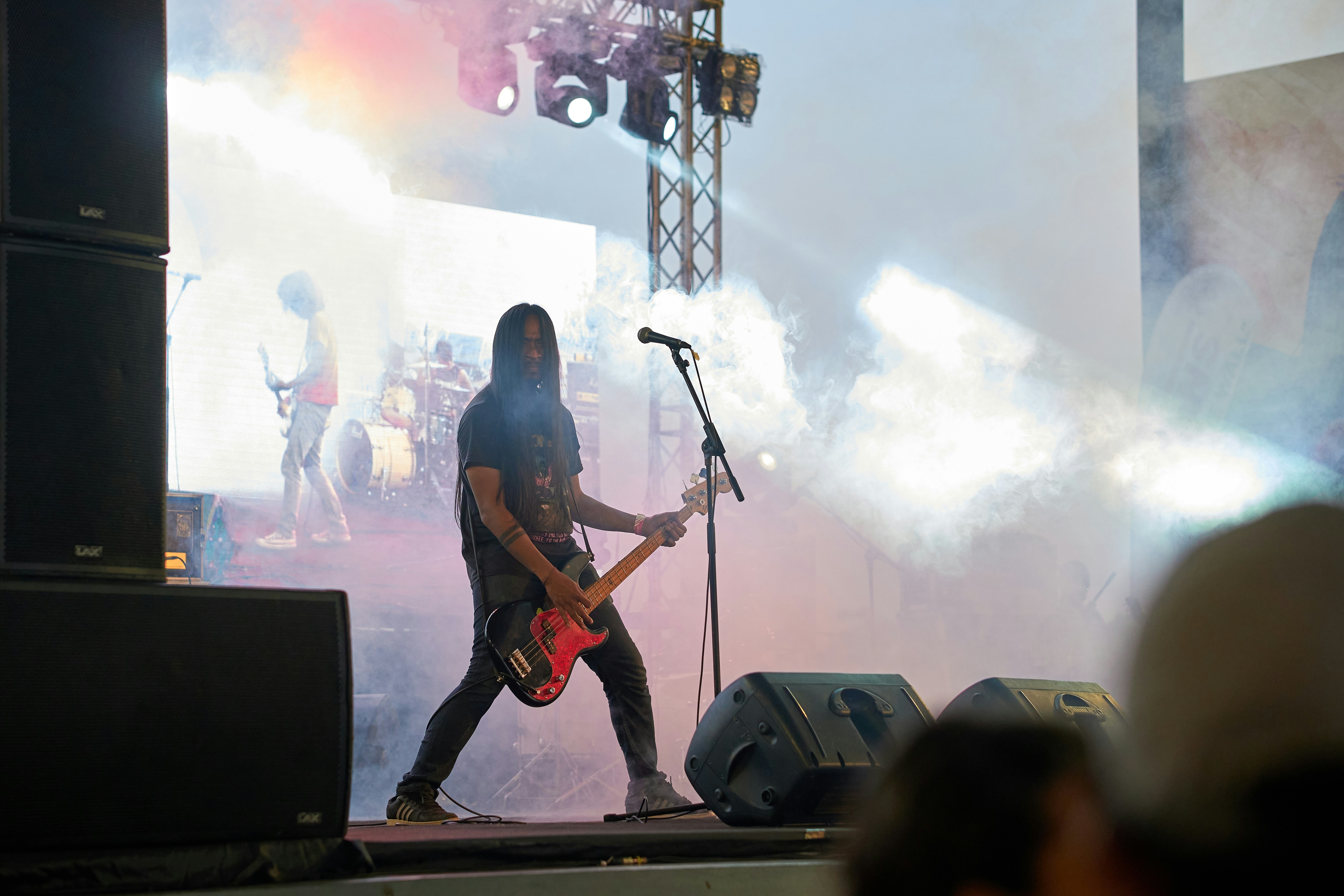 Bassist spielt live mit seiner Band auf der Bühne.